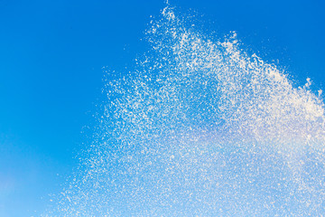 water splashing from the fountain in the background of blue sky