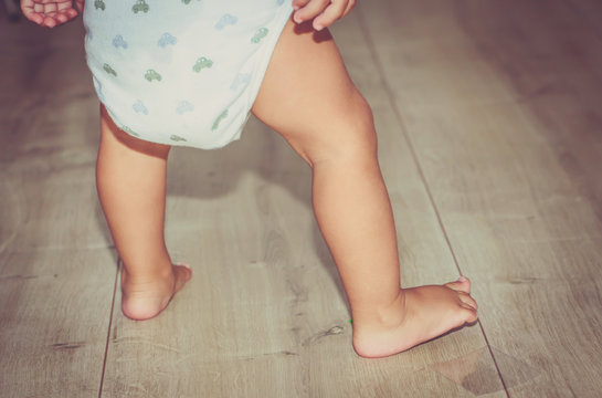 Beine eines kleinen Kindes mit Windel,-  Kind steht auf dem Fußboden