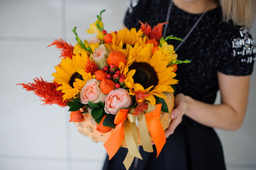 Naklejka premium Young girl holding a bouquet of sunflowers