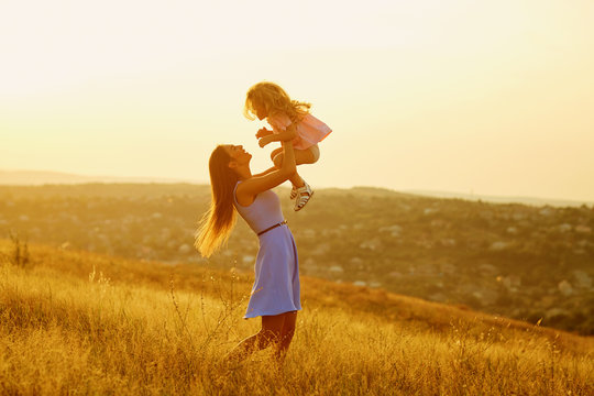 Mother and daughter in nature at sunset. Mothers Day.