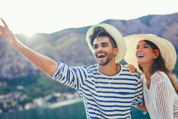 Happy young couple walking by the harbor of a touristic sea resort