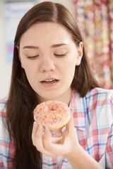 Guilty Looking Teenage Girl On Diet Eating Donut