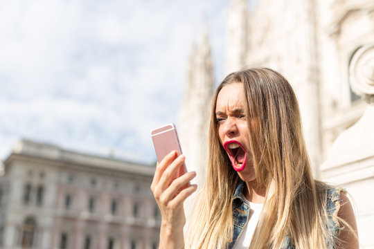 Angry and upset teenager screaming at the mobile telephone