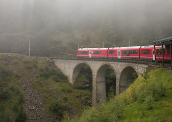 Obraz premium Trenino rosso del Bernina tra la nebbia nelle alpi Svizzere