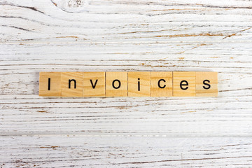 INVOICES word made with wooden blocks concept