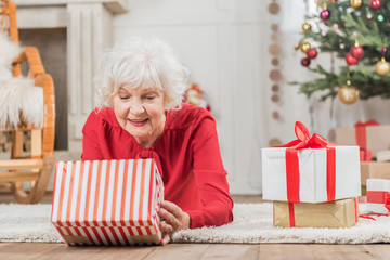 Obraz na płótnie Canvas Cheerful mature woman is holding present box