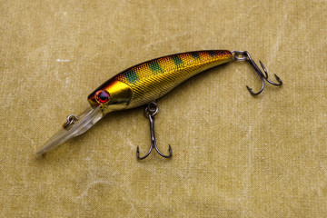 A bait for fishing on a tarpaulin background. Wobblers of different colors.