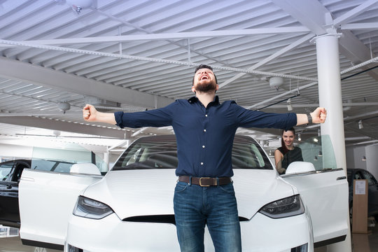 man chooses the car in the showroom