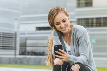 young beautiful girl with long hair  hearing a music with smart phone outdoor