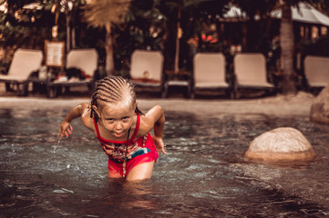 little girl is splashing in the pool