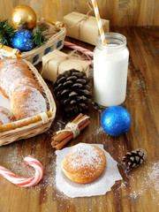 Donuts berliner and a glass of milk surrounded by Christmas attributes