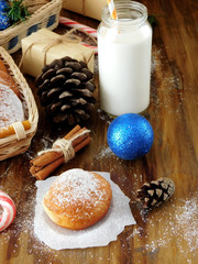 Donuts berliner and a glass of milk surrounded by Christmas attributes