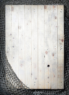 Fishing nets over wooden background with copy space.