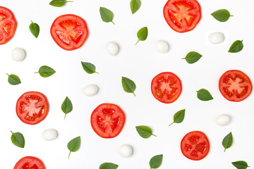 Colorful pattern of tomatoes, basil and mozzarella on a white background. Top view of a classic combination of tomatoes and mozzarella cheese. The concept of a healthy diet