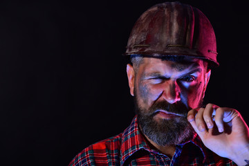 Guy with brutal image wears dirty helmet and plaid shirt