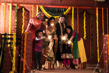 stock photo of Indian Family celebrating Diwali festival with fire crackers with grand parents,...