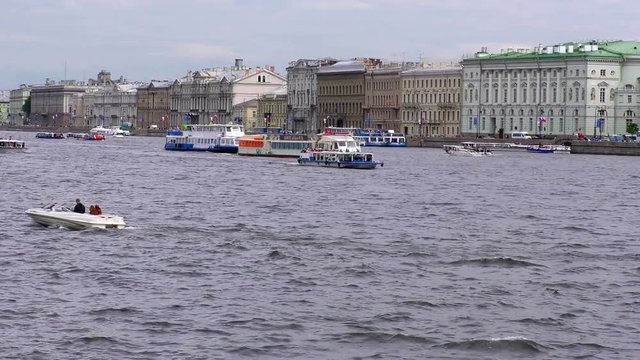 Passenger excursion ships and boats float on the Neva river past Hermitage in Saint Petersburg, Russia. The tourist season in the Historic city Museum.