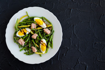 Warm salad with cooked green beans, tuna and boiled eggs