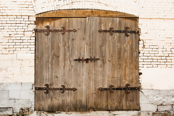Aged Old Wooden Door With Lock On Old Brick White Wall. Ancient Style.