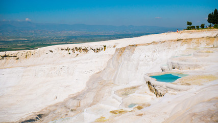 Incredible surface of the shimmering, snow-white limestone, shaped over millennia by calcium-rich springs. Pamukkale, Turkey.