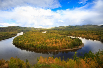 beautiful autumn landscape with river and forest under blue sky