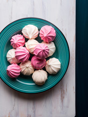 Pastel color pink and white meringue on green background