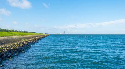 Obraz premium Dike along the shore of a lake in sunlight in summer
