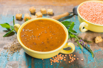 Homemade red lentils soup in yellow bowl