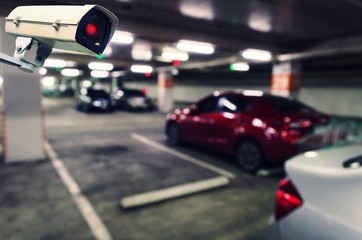 CCTV, security indoor camera system operating with blurred image of under ground indoor car parking garage area, RFID solution management system, surveillance security and safety technology concept
