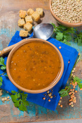 Homemade brown lentils soup in old clay bowl