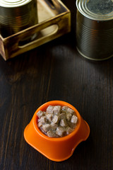 Canned pet food in a orange plastic bowl.