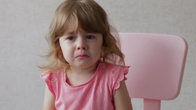 Toddler girl crying with mouth wide open and tears down her face