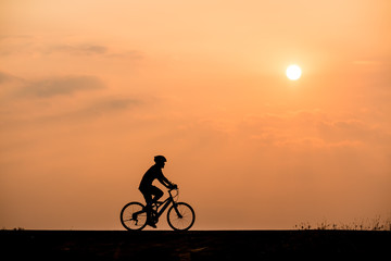 Obraz na płótnie Canvas Silhouette of cyclist on sunset background