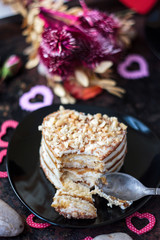 Beautiful dessert starting to eat, on black plate with metal spoon.