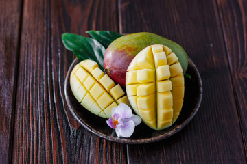 Fresh ripe mango with leaves and flower over wooden table