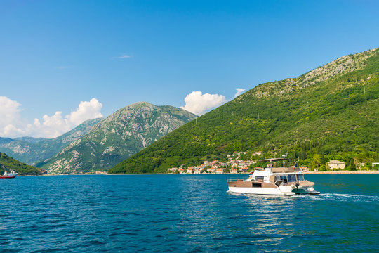 Fototapeta MONTENEGRO, KAMENARI - JUNE 04/2017: tourists swim in the Boka Kotorska Bay on a motor catamaran.