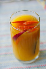 Mango and orange smoothie in transparent glass.