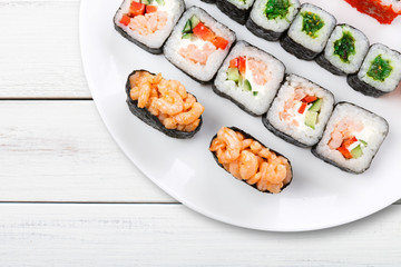 Colorful set of sushi and rolls top view on white wood, closeup