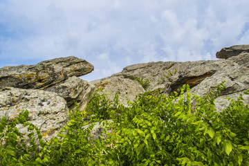 The top of one of the red sandstones with its numerous caves under the cloudy sky.