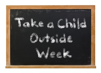Take a child outside week written in white chalk on a black chalkboard isolated on white