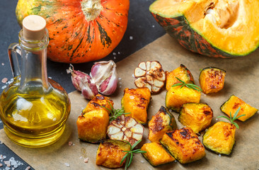 Baked pumpkin slices with garlic, rosemary, olive oil and salt. Snack for gourmets. Selective focus