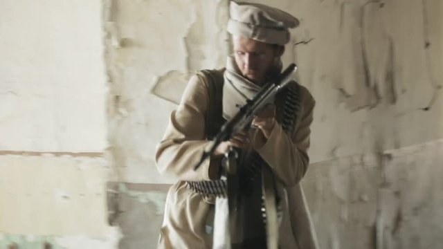 Man with the rifle aiming and shooting at the enemy in the corridor of the abandoned building