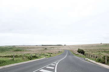 Beautiful scene long destination road through the field on non-urban side with cloudy