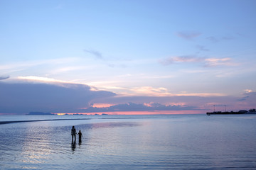 Fototapeta premium children and parent holding hand looking to the sea at sunset, family, peaceful concept.