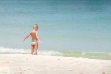 European boy age 3-5 years old stands on the beach, Opening arm.