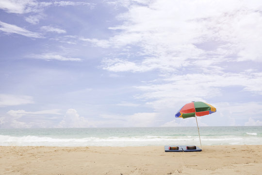 Vacation time at Phuket, Thailand, Mat, and Pillow under the umbrella at the beach. Cloudy background