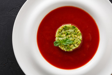 Cold tomato soup gazpacho with avocado close up