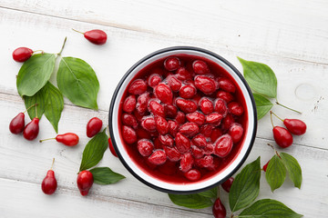 Cornus or dogwood jam with berries on a white wooden background, autumn seasonal