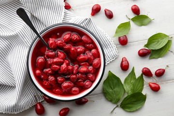 Cornus or dogwood jam with berries on a white wooden background, autumn seasonal