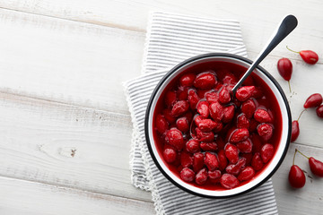Cornus or dogwood jam with berries on a white wooden background, autumn seasonal